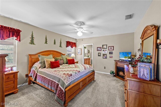 carpeted bedroom featuring ensuite bath and ceiling fan