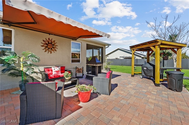 view of patio with a gazebo, a grill, and an outdoor living space with a fireplace