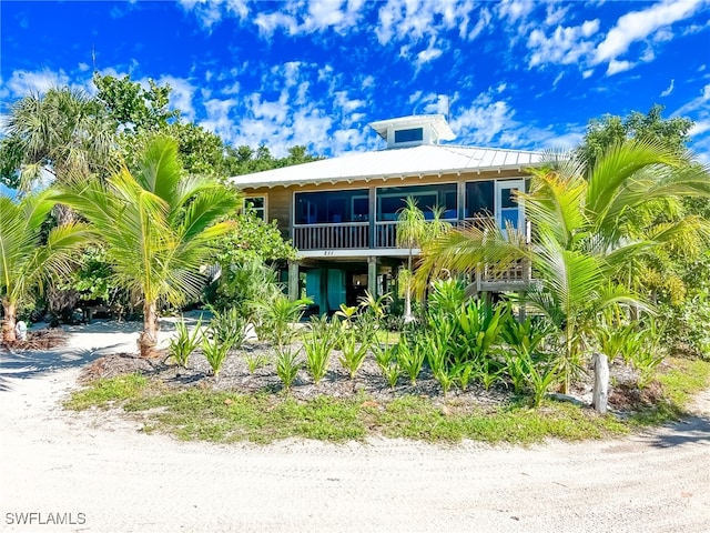 raised beach house featuring a sunroom