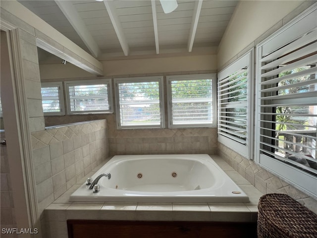 bathroom with vaulted ceiling with beams, a healthy amount of sunlight, and tiled tub