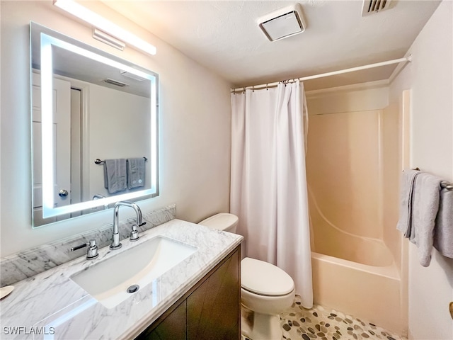 full bathroom featuring a textured ceiling, vanity, shower / bath combo, and toilet