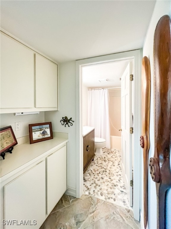 full bathroom featuring vanity, shower / tub combo, and toilet