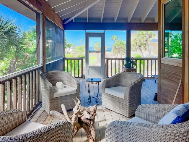 sunroom / solarium featuring lofted ceiling with beams