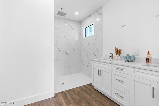 bathroom with tiled shower, vanity, and hardwood / wood-style flooring