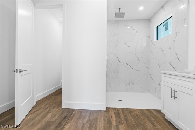 bathroom featuring tiled shower, toilet, vanity, and hardwood / wood-style flooring