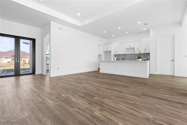 unfurnished living room featuring dark wood-type flooring and french doors