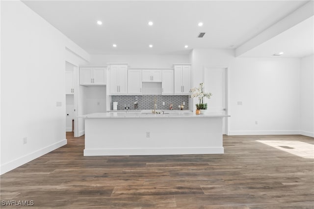 kitchen with a center island with sink, white cabinetry, and dark wood-type flooring