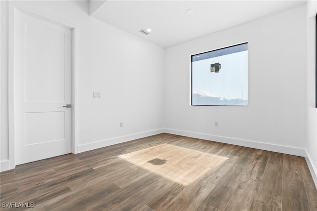 unfurnished room with hardwood / wood-style flooring