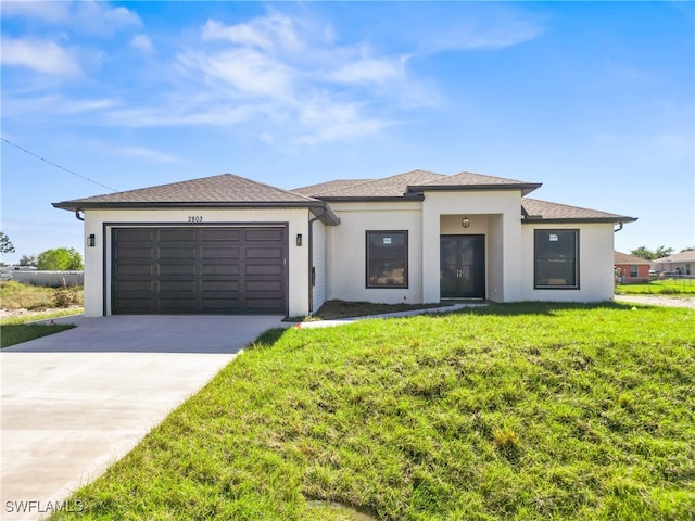 view of front of property with a garage and a front lawn