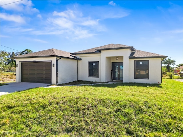 view of front of home with a front lawn, a garage, and french doors