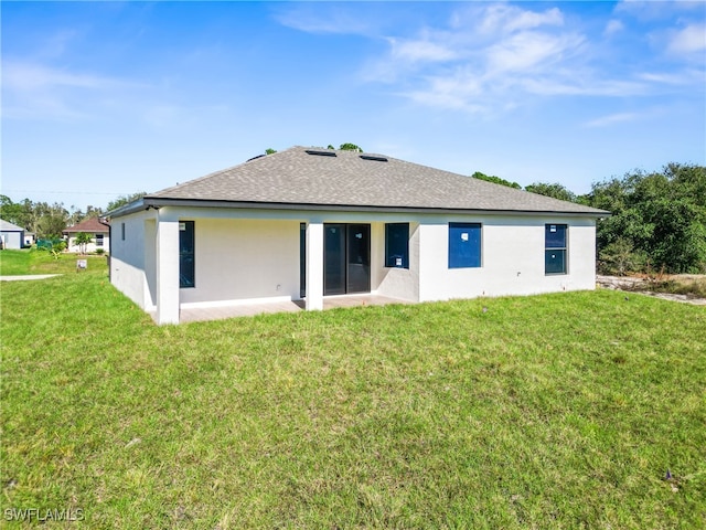 rear view of property featuring a lawn