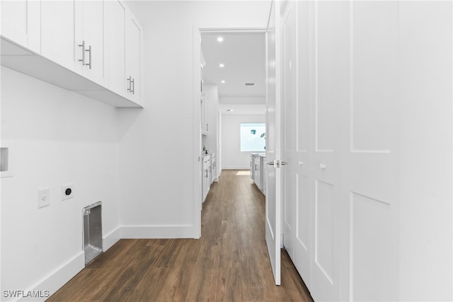 laundry room with electric dryer hookup, dark wood-type flooring, and cabinets