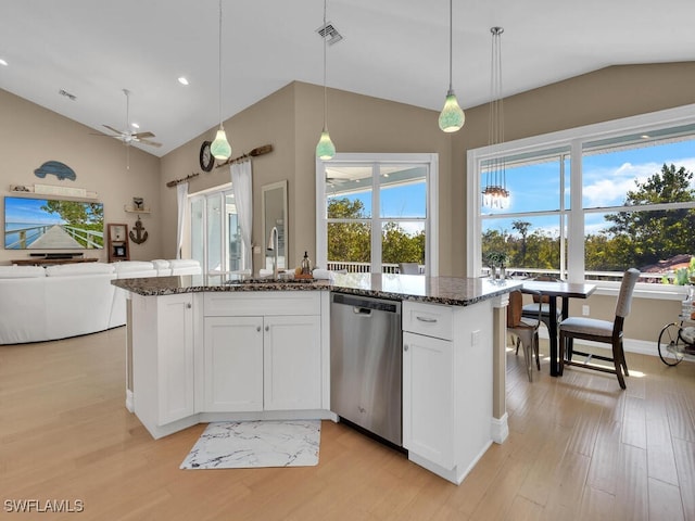 kitchen with stainless steel dishwasher, dark stone counters, sink, pendant lighting, and white cabinetry