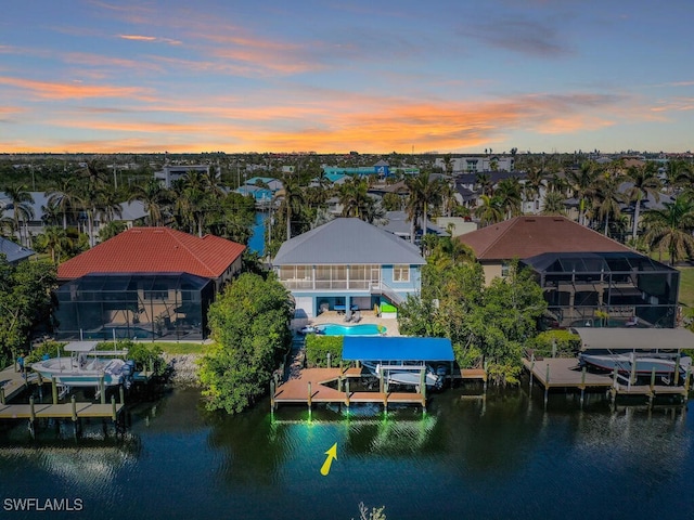 aerial view at dusk featuring a water view