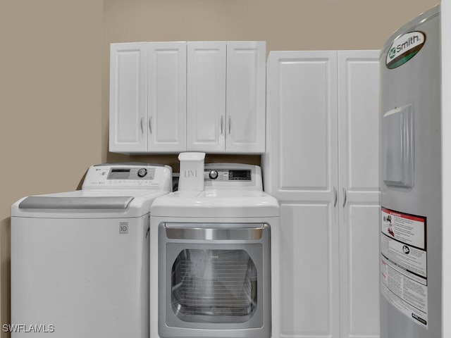 laundry room featuring cabinets, electric water heater, and washing machine and dryer