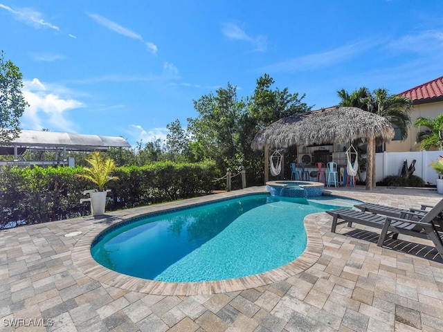 view of pool featuring an in ground hot tub, a patio, and exterior bar