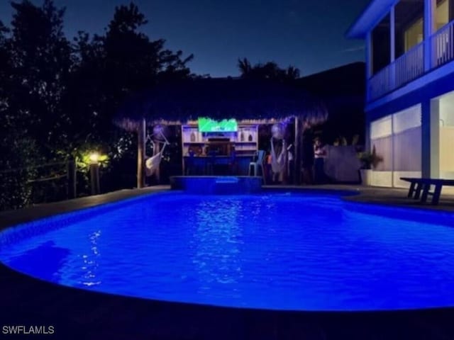 pool at twilight with a hot tub