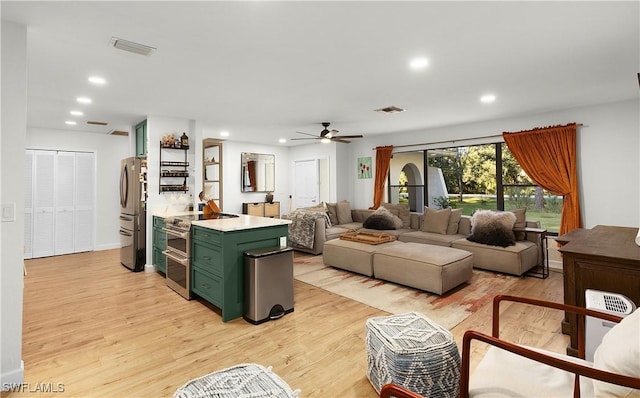 living room featuring light hardwood / wood-style flooring and ceiling fan