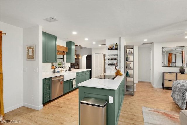 kitchen with stainless steel dishwasher, green cabinets, and light hardwood / wood-style flooring