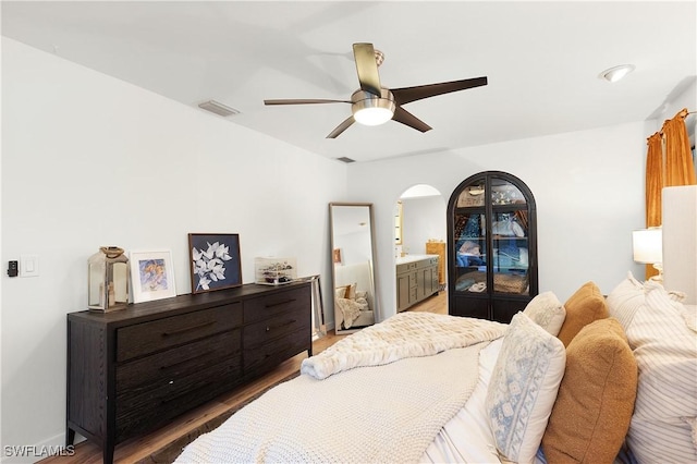 bedroom with hardwood / wood-style floors, ceiling fan, and ensuite bathroom