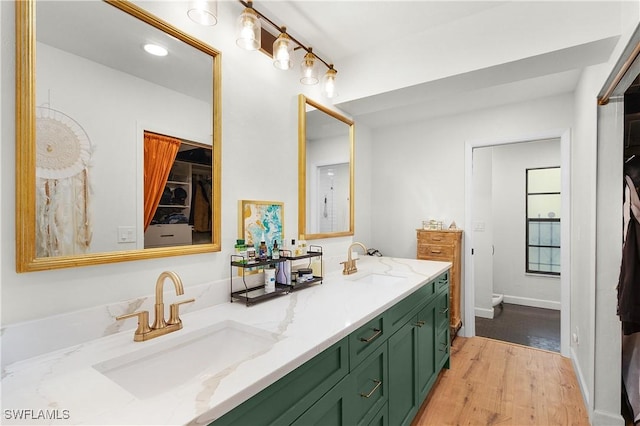 bathroom with vanity, toilet, and wood-type flooring