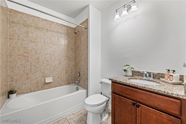 full bathroom featuring tile patterned flooring, vanity, toilet, and tiled shower / bath combo