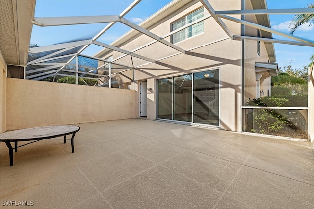 view of patio featuring glass enclosure