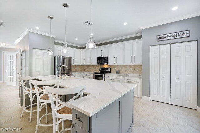 kitchen with tasteful backsplash, a large island, white cabinets, sink, and stainless steel appliances