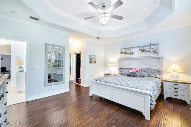 bedroom with dark hardwood / wood-style floors, a closet, a tray ceiling, and ceiling fan