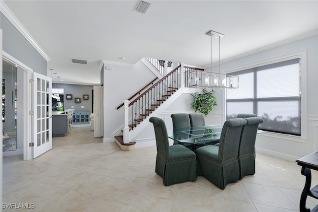 dining area featuring a chandelier, light tile patterned floors, and ornamental molding