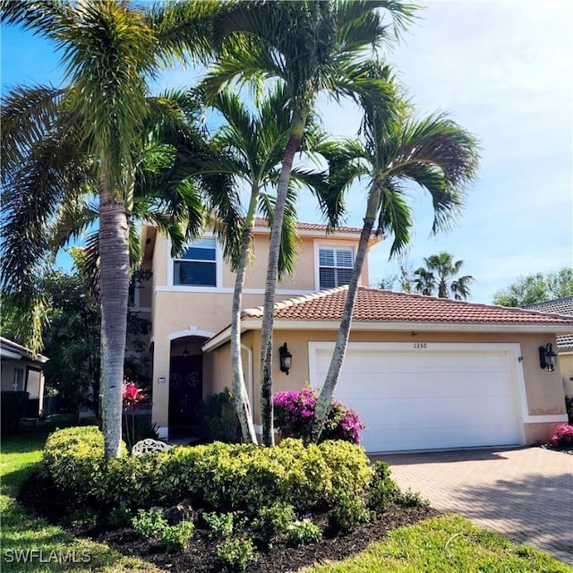 1350 Triandra Ln, Naples, FL 34119 - view of front of property with stucco siding, decorative driveway, an attached garage, and a tile roof