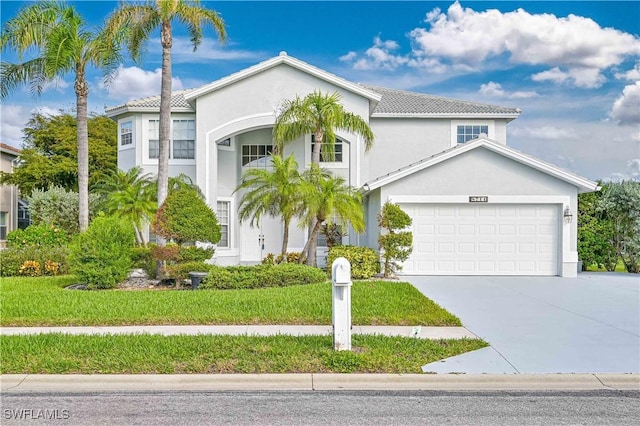 view of front of property with stucco siding, a front lawn, and driveway