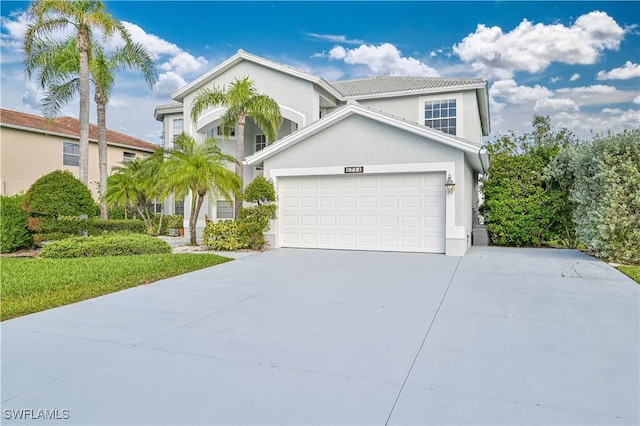 view of front facade featuring stucco siding, concrete driveway, and a garage