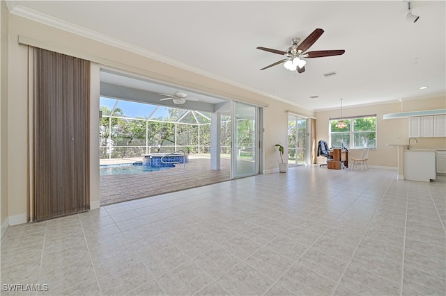 unfurnished living room featuring a sink, baseboards, a sunroom, and ornamental molding