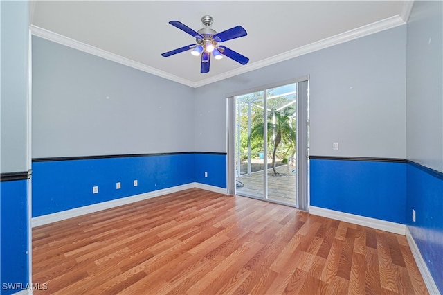 unfurnished room with baseboards, a ceiling fan, wood finished floors, and crown molding