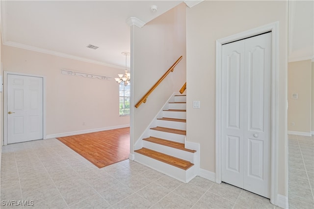 stairway with a chandelier, visible vents, crown molding, and baseboards