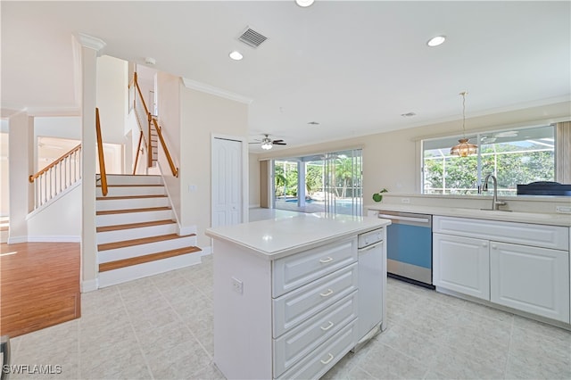 kitchen with dishwashing machine, crown molding, light countertops, and visible vents