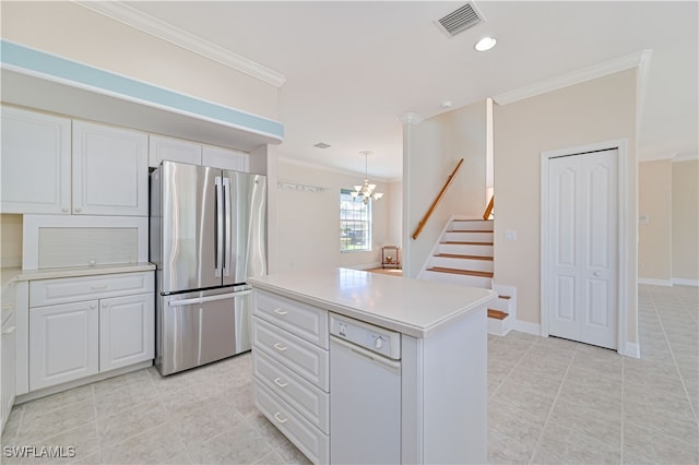 kitchen featuring white cabinets, light countertops, freestanding refrigerator, and ornamental molding