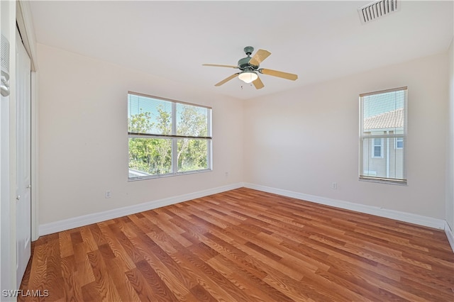 empty room featuring visible vents, baseboards, a healthy amount of sunlight, and light wood-style flooring