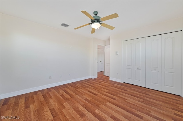 unfurnished bedroom featuring visible vents, ceiling fan, baseboards, light wood-type flooring, and a closet