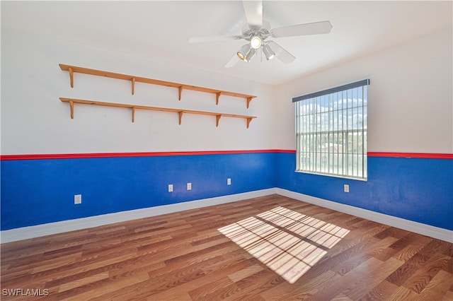 empty room with wood finished floors, baseboards, and ceiling fan