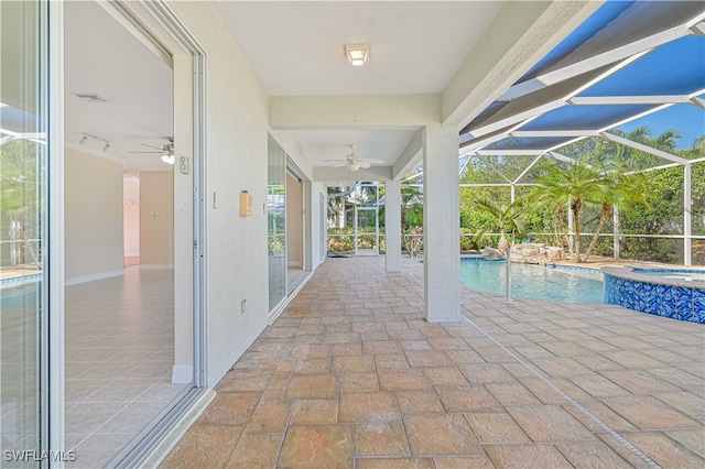 view of pool featuring glass enclosure, a patio, a ceiling fan, and a pool with connected hot tub