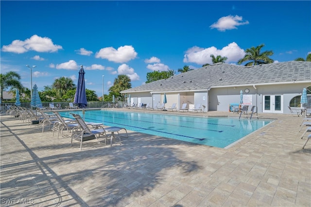 pool featuring a patio area, fence, and french doors