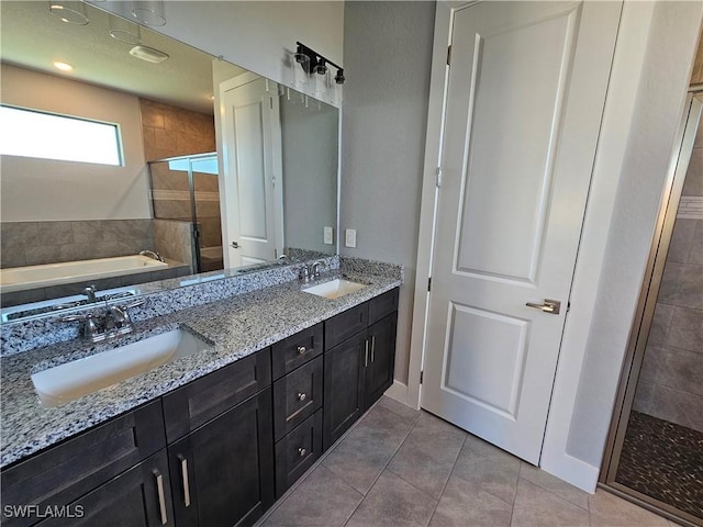 bathroom with shower with separate bathtub, vanity, and tile patterned floors