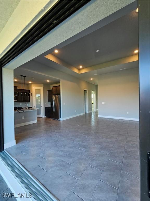 unfurnished living room featuring a tray ceiling