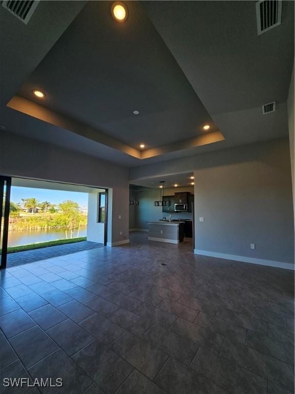 unfurnished living room featuring a tray ceiling