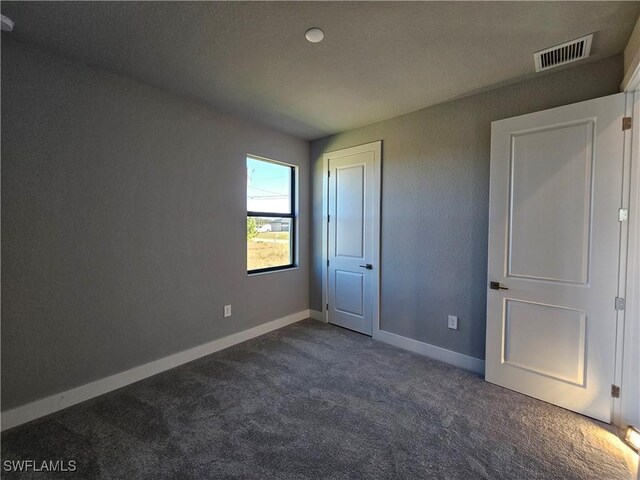 unfurnished bedroom featuring dark carpet