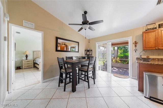 dining room with ceiling fan, light tile patterned floors, and vaulted ceiling