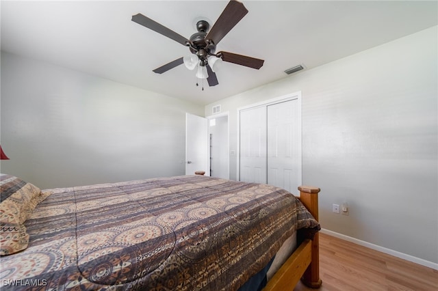 bedroom with light wood-type flooring, a closet, and ceiling fan