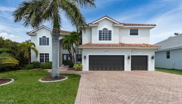 mediterranean / spanish house with a garage and a front lawn